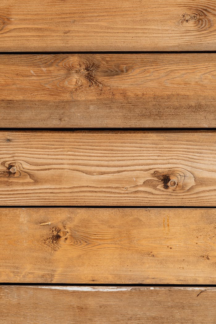 our-story Close-up of natural wood planks with distinct wood grain patterns and knots, ideal for design backgrounds.